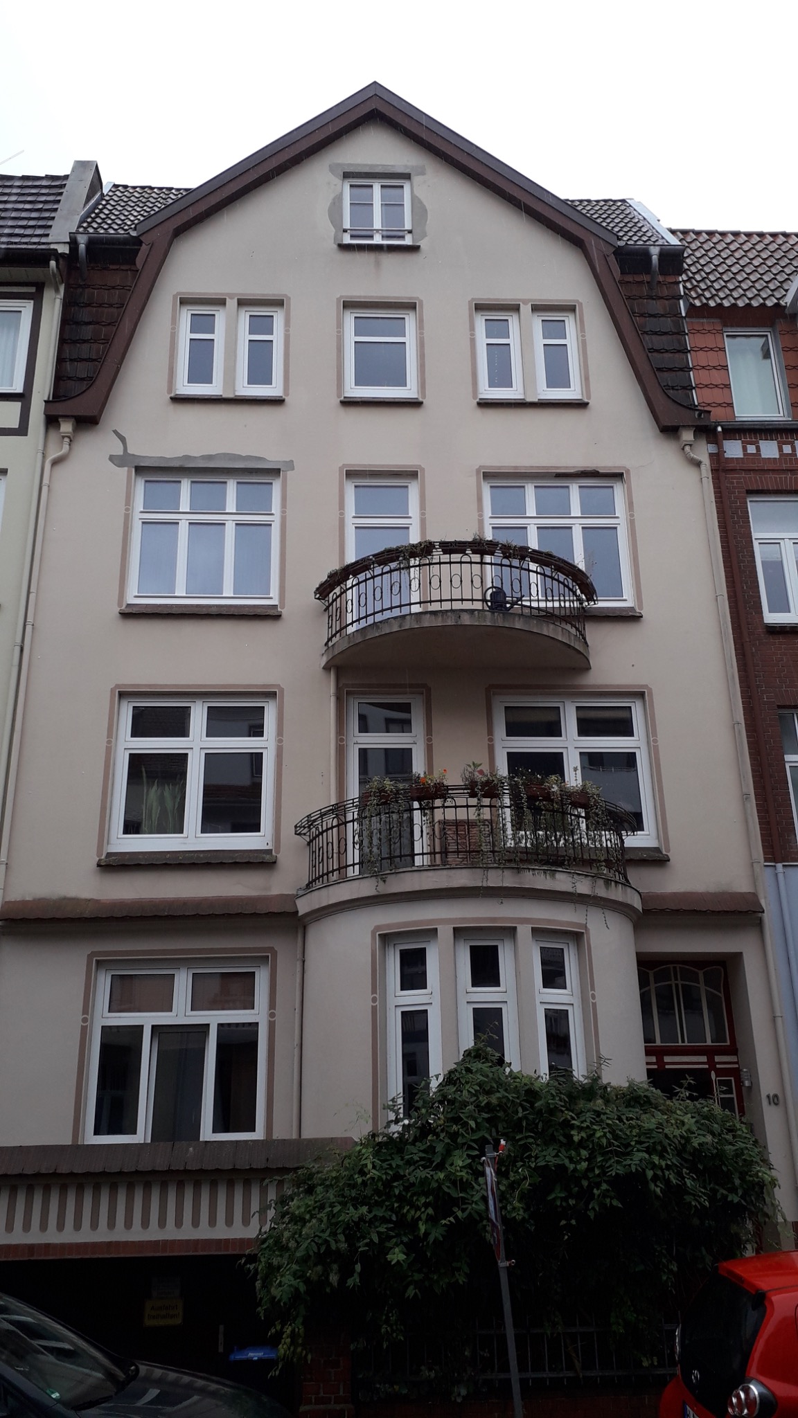 Mehrgeschossige Fassade mit weißen Fenstern und Erkern